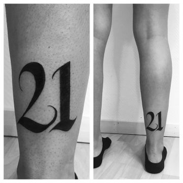Tatouage calligraphie « 21 » sur le mollet
