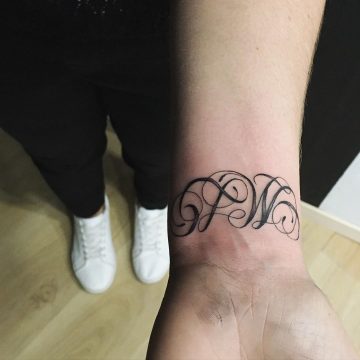 Tatouage Calligraphie initiales « M L » sur le poignet